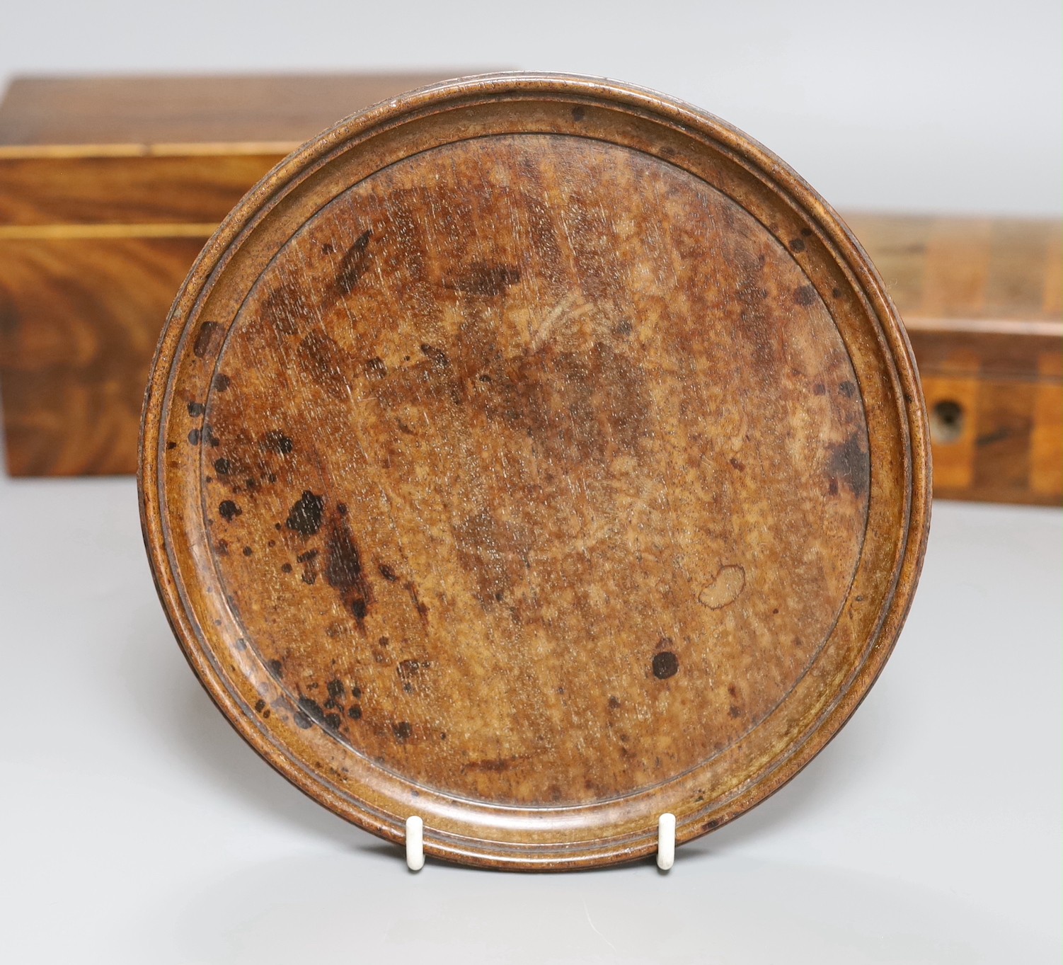 A George III inlaid mahogany tea caddy, a Victorian satinwood and rosewood domed topped glove box, a burr wood circular tray, a George III inlaid mahogany domed topped easel mirror and a pair of turned hardwood cups